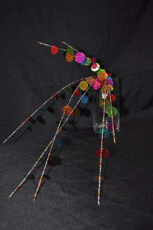 Branche décorative avec paillettes multicolores.